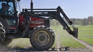 Traktor på en åker, ur profil