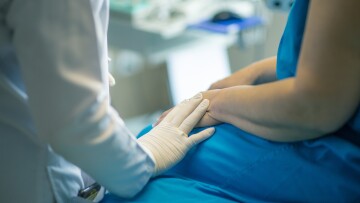 Sjukhusmiljö, en vårdarens hand på patientens
