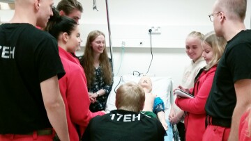 Vårdstuderande samlade runt en patientsäng