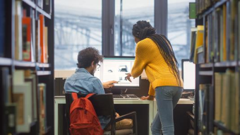 two students in library with their backs to the camera