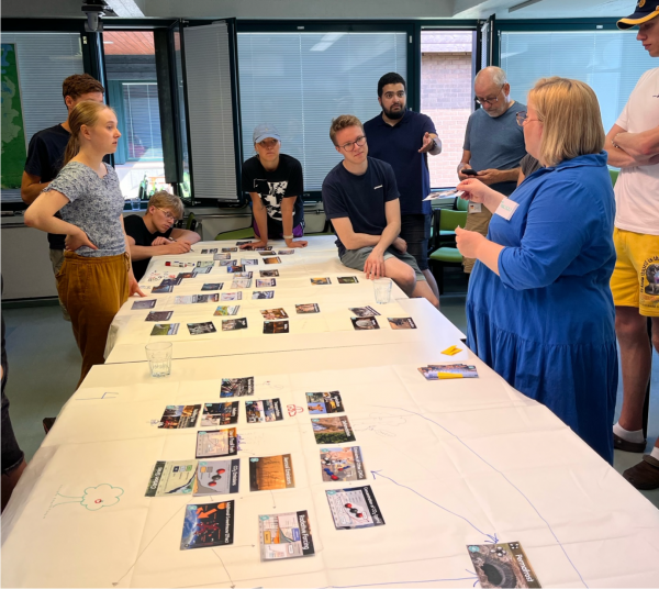 En grupp människor utför en workshop kring ett bord.