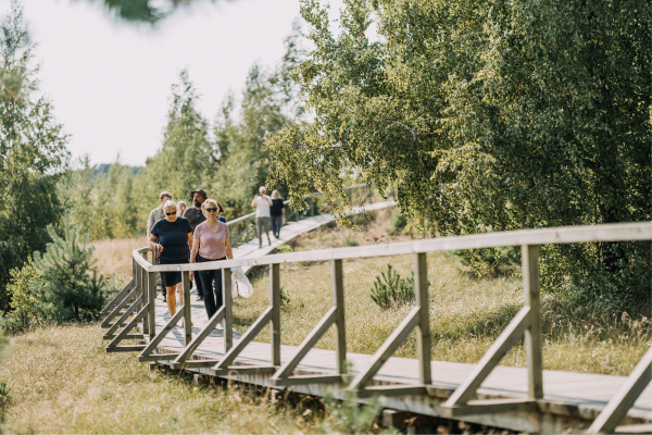 En grupp människor går på en träspång i naturen