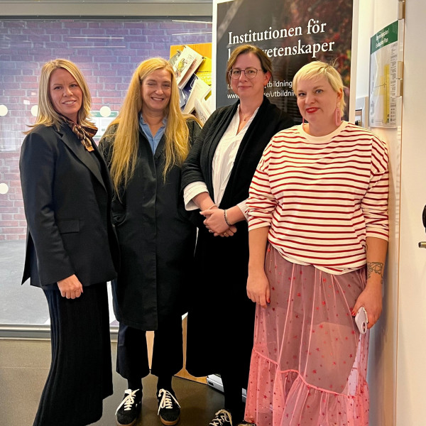 Fyra kvinnor står bredvid varandra och ler mot kameran.