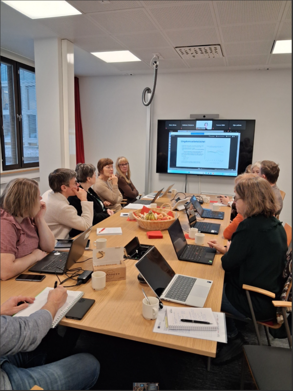 En grupp människor runt ett mötesbord.