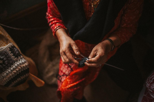 A picture of a woman's hands, knitting.
