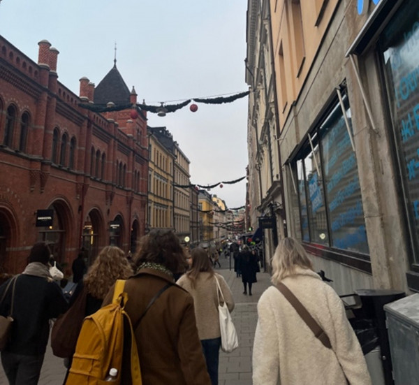 Människor fotade bakifrån som går på en gata i Stockholm.