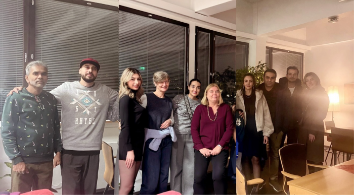 A group of people posing and looking into the camera. 