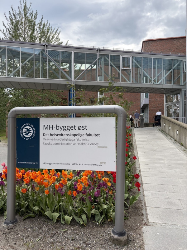 En skylt framför en universitetsbyggnad.