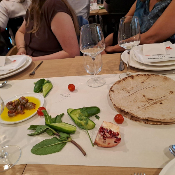 A table set for dinner with a white tablecloth in the middle and food placed on top.