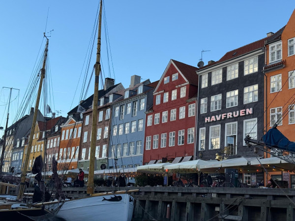 En bild av en rad färgranna hur i Köpenhamn med ett vattendrag i förgrunden.